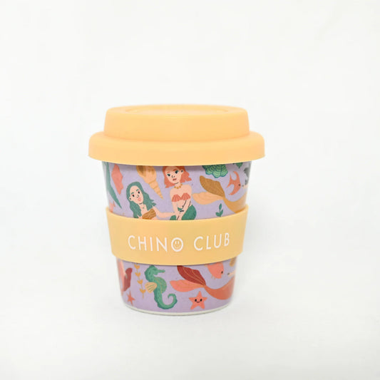 Mermaid baby chino cup for coffee or hot chocolate. Purple background with images of mermaids with yellow lid.